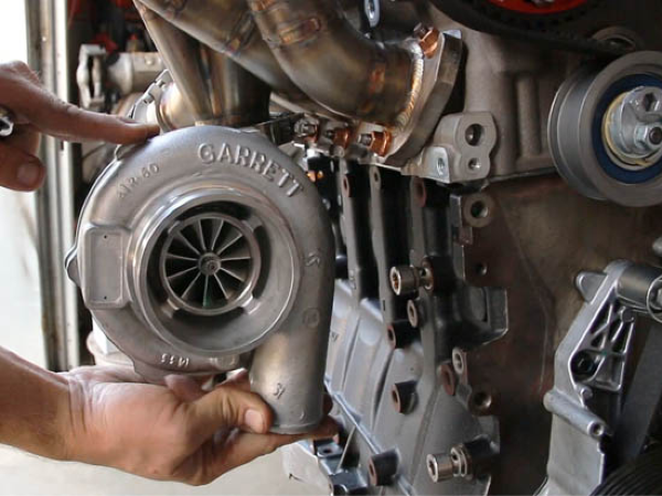 Turbocharger installation on an engine with visible Garrett branding, showcasing performance upgrades for import vehicles at EuroX Performance.